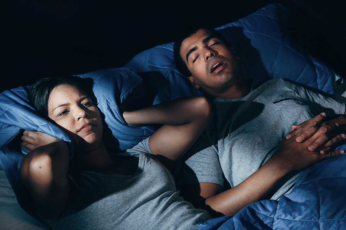 Woman awake in bed with snoring partner